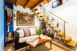 a living room with a couch and a staircase at Petalidi Sunny Home One - Charming Garden Nest in Petalidi