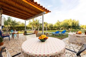 a table with a bowl of fruit on a patio at Petalidi Sunny Home One - Charming Garden Nest in Petalidi