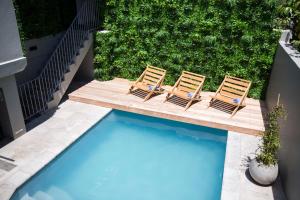 two chairs sitting next to a swimming pool at Antrim House by Totalstay in Cape Town