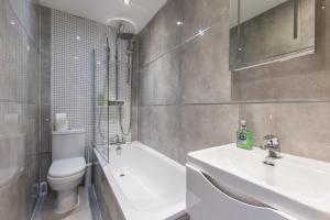 a bathroom with a toilet and a sink and a tub at Modern1-Bed - Central Croydon in South Norwood