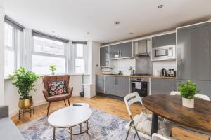 a kitchen and living room with a table and chairs at Modern1-Bed - Central Croydon in South Norwood