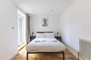 a bedroom with a white bed with two pillows at Modern1-Bed - Central Croydon in South Norwood
