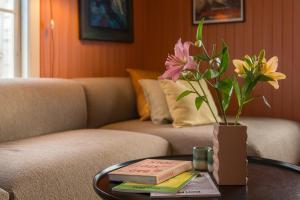 LøkenExperience Jotunheimen from Vevstogo - sauna with a view and eco living in an old school building的一张桌子,长沙发上放着花瓶