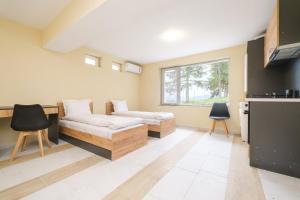 a living room with two couches and a window at Veliko Turnovo Studios - Stylish & Convenient in Veliko Tŭrnovo
