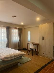 a bedroom with a bed and a desk and a chair at Yushi Stay Patan Flat 1 in Pātan