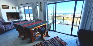 a table in a room with a view of the ocean at Columbine Views in Stompneusbaai