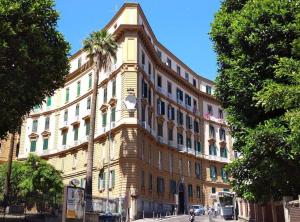 a large building with a palm tree in front of it at Casa Margherita in Naples