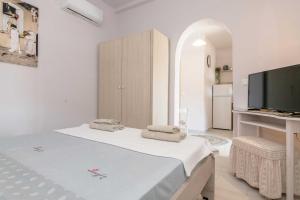 a white room with a bed and a tv at Λεβάντα in Lichnaftia