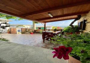 a patio with a table and a red flower at Nikos Traditional House in Maláthiros
