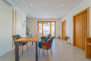 a dining room with a wooden table and chairs at Nuova -Luxury Rooms & Apartment- in Olbia
