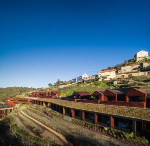 a train on a track with buildings on a hill at Longroiva Hotel Rural in Longroiva