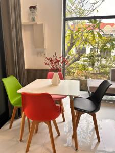 a table and chairs in a room with a window at MUN HOMESTAY in Hue