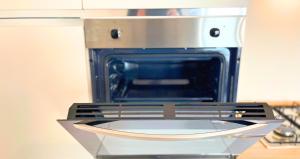 a stove with an open oven in a kitchen at Vela House & Garden City Center in Olbia