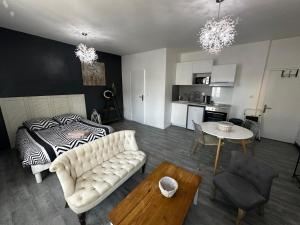 a living room with a couch and a bed and a table at Le Caly - 2mn gare SNCF, hyper centre, WIFI-NETFLIX in Niort