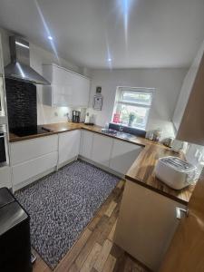 a kitchen with white cabinets and a rug on the floor at LANGLEY APARTMENT free parking outside between 6 pm and 8 am Secure parking 2 min walk Ideal for TRADES AND TOURISTS WANTING GREAT LOCATION in Inverness
