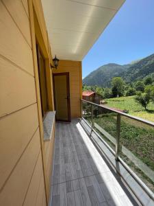 a balcony of a house with a door and a view at Salegan Pansiyon in Uzungöl