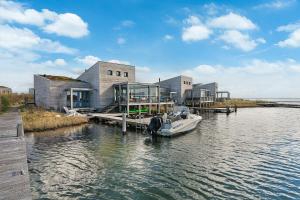 un barco está atracado frente a un edificio sobre el agua en Villa Super VIP - 4 Pers met jacuzzi - Villa 7, en Ouddorp
