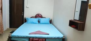 a bedroom with a blue bed with a mirror at CERRY BERRY Homestay in Guwahati