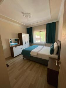 a bedroom with a bed and a television in it at Salegan Pansiyon in Uzungöl