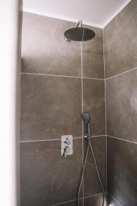 a shower with a shower head in a bathroom at Ikigai Fontainebleau - Cottage in Villiers-sous-Grez