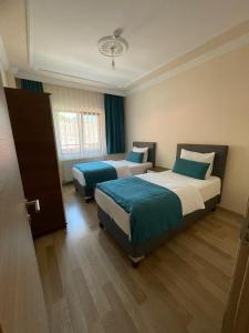 a hotel room with two beds and a window at Salegan Pansiyon in Uzungöl +6 photos