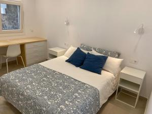 a bedroom with a bed with blue pillows and a desk at VV Sal y Mar Apartment in Los Cancajos +36 photos