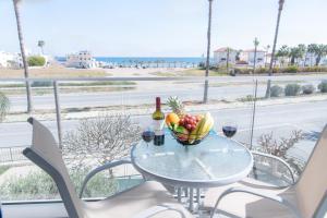 una mesa con un bol de fruta y una botella de vino en Themis Beach Apartments, en Lárnaca