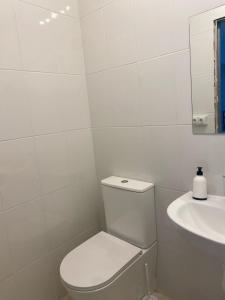 a white bathroom with a toilet and a sink at Casa Trasande in Couso +13 photos