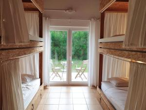 a room with two bunk beds and a sliding glass door at Endless Summer Surf House in Aljezur
