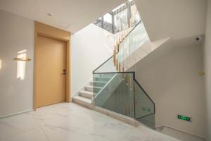 een hal met een glazen trap en een deur bij Dali Qiyu Half Hill Seaview Villa - Erhai Branch in Dali