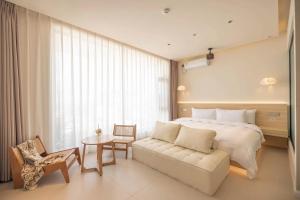 een slaapkamer met een bed, een bank en een tafel bij Dali Qiyu Half Hill Seaview Villa - Erhai Branch in Dali +33 foto's