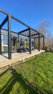 a house with a wooden deck in the grass at B&B NR6 in Herbaijum