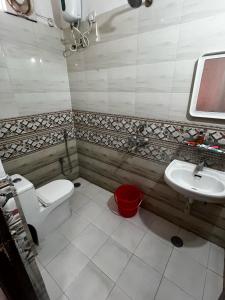 a bathroom with a toilet and a sink at Mannat Enclave in Haidar Sāhibgūda
