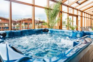 a jacuzzi tub in a room with a large window at Tci Social Club in Cluj-Napoca