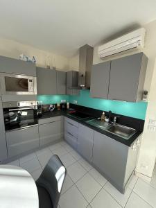 a kitchen with gray cabinets and a sink at Magnifique T2 Athena in Bandol +6 photos