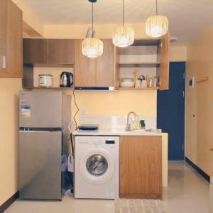 a kitchen with a washing machine and a refrigerator at Madera Suites Mactan in Lapu Lapu City