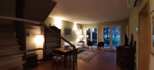 a living room with a staircase and a living room with a table at Fienile FICO Fiera in Bologna