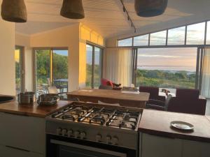 a kitchen with a stove and a view of a living room at Sarah's Place -Stilbaai in Stilbaai