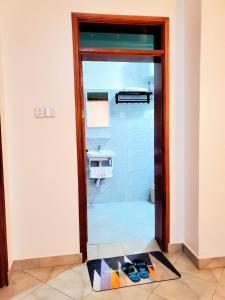 a bathroom with a glass door in a room at La Vista Residences and Safaris in Jinja