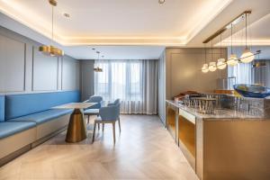 南寧市にあるMido Hotel - Nanning Anji Wanda Plaza Branchのキッチン(バー、テーブル、椅子付)