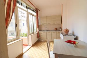 a kitchen with a table and a large window at Casa Isabel a Otranto in Otranto