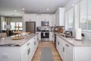 Una cocina con gabinetes blancos y encimera. en Cottage on the Plains, en Auburn