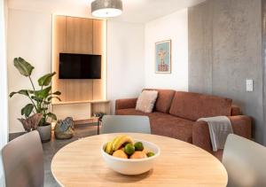 a living room with a table with a bowl of fruit on it at Lake-Apart Apartamenty Mielno in Mielno