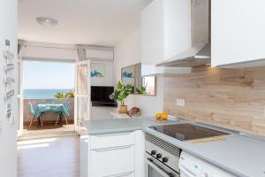 a kitchen with white cabinets and a view of the ocean at Levante19 Estudio Naturista primera línea in Vera