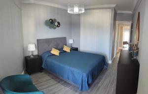 a bedroom with a blue bed and a blue chair at Bela Vista Solmar 3 B/R in Ponta Delgada