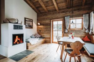 ein Wohnzimmer mit Kamin und Tisch in der Unterkunft Alpzitt-Chalets in Burgberg