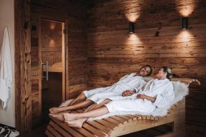 zwei Personen in einem Bett in einer Sauna in der Unterkunft Alpzitt-Chalets in Burgberg