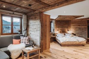 ein Schlafzimmer mit einem Bett und einer Holzwand in der Unterkunft Alpzitt-Chalets in Burgberg
