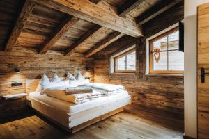 ein Schlafzimmer mit einem Bett in einem Holzzimmer in der Unterkunft Alpzitt-Chalets in Burgberg