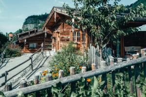ein Holzhaus mit einem Zaun davor in der Unterkunft Alpzitt-Chalets in Burgberg